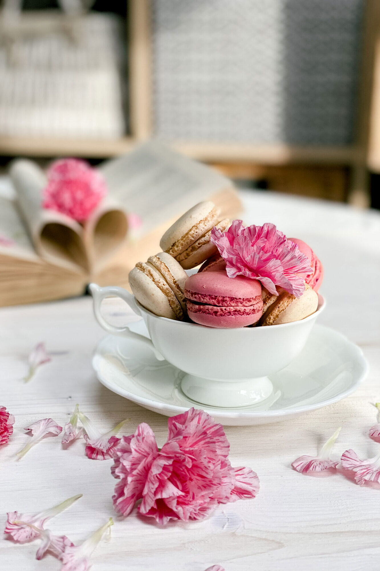 A professional food photography ecommerce product photo of a porcelain cup filled with macaroons in light, airy and romantic design