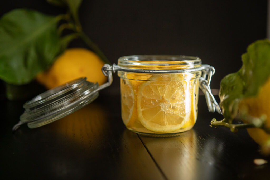 a product ecommerce photography food image with a glass jar with sugar lemons in a dark and moody set up